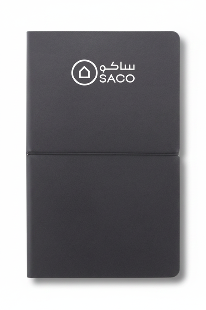 Dark grey notebook with SACO logo in white on top
